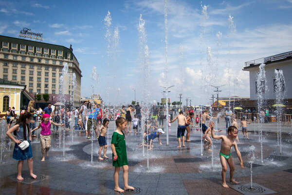 People are cooling in the fountain on a hot day in central Kiev, Ukraine