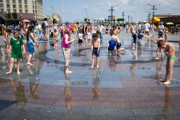 La gente se está enfriando en la fuente en un día caluroso en el centro de Kiev, Ucrania — Foto de Stock
