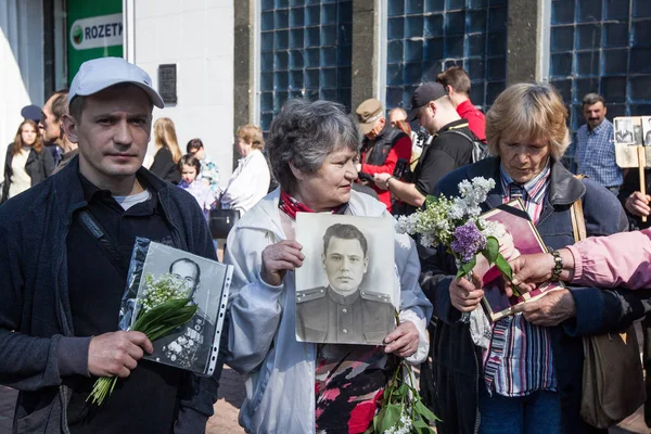 Люди беруть участь у демонстрація Меморіал Безсмертний полку з портрети родичів, які брали участь у другій світовій війні, в центрі Києва — стокове фото