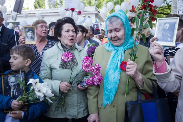 Люди беруть участь у демонстрація Меморіал Безсмертний полку з портрети родичів, які брали участь у другій світовій війні, в центрі Києва — стокове фото