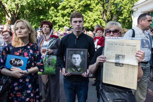 Люди беруть участь у демонстрація Меморіал Безсмертний полку з портрети родичів, які брали участь у другій світовій війні, в центрі Києва — стокове фото