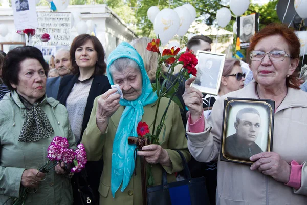 Люди беруть участь у демонстрація Меморіал Безсмертний полку з портрети родичів, які брали участь у другій світовій війні, в центрі Києва — стокове фото