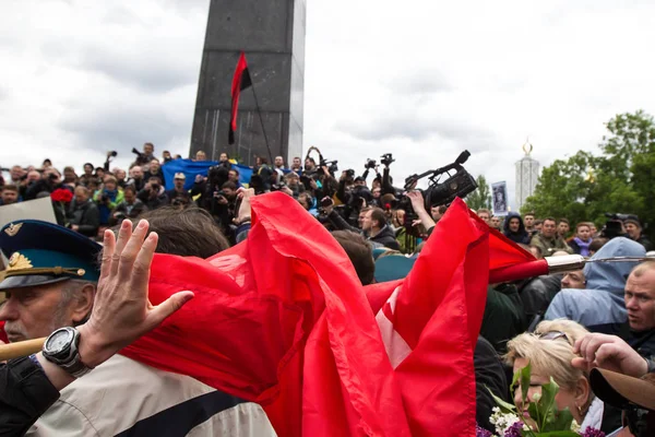 Aktivister från högerextrema radikala organisationer försöker bryta kommunistiska flagga under en procession dag av segern av Sovjetunionen under andra världskriget i Kiev, Ukraina — Stockfoto