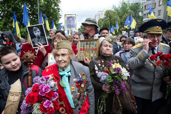 Люди беруть участь у демонстрація Меморіал Безсмертний полку з портрети родичів, які брали участь у другій світовій війні, в центрі Києва — стокове фото