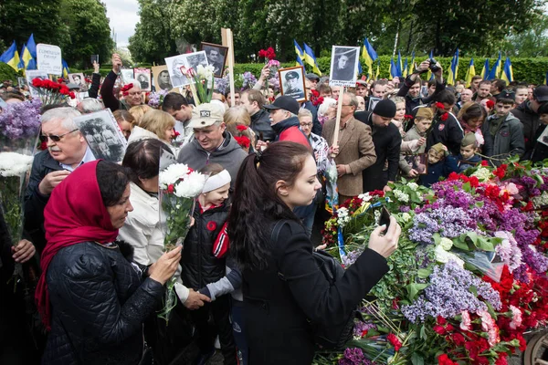 Люди беруть участь у демонстрація Меморіал Безсмертний полку з портрети родичів, які брали участь у другій світовій війні, в центрі Києва — стокове фото