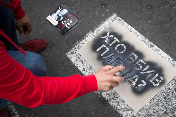 A man paints on asphalt a call to investigate the murder of a Belarusian journalist Pavel Sheremet in Kyiv, Ukraine — Stock Photo, Image