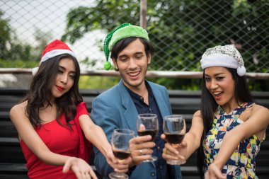 Parti içinde cam tutan genç insanlar konuşmak.