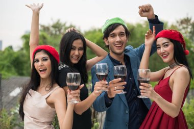 Parti içinde cam tutan genç insanlar konuşmak.