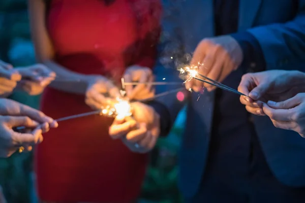 Jovens com fogos de artifício em uma festa . — Fotografia de Stock