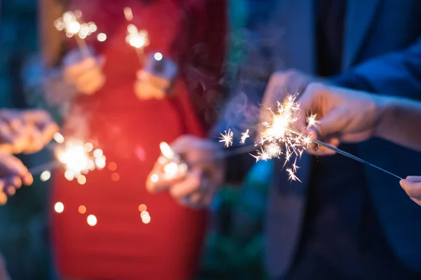 Young people holding fireworks at a party. — Stock Photo, Image