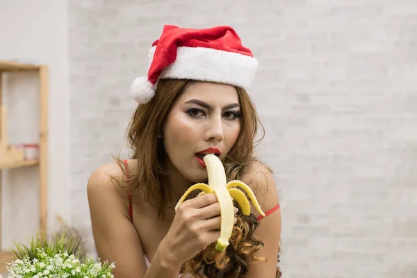Sexy kobiety w Santa dress jedzenie pyszne banany. — Zdjęcie stockowe