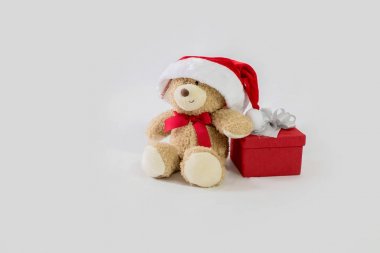 Beyaz bir arka plan üzerinde Noel Baba giysili oyuncak ayı.