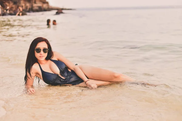 Hermosa mujer usando un traje de baño jugando en la playa . — Foto de Stock