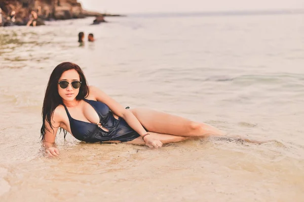 Schöne Frau im Badeanzug spielt am Strand. — Stockfoto