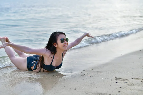 Hermosa mujer usando un traje de baño jugando en la playa . — Foto de Stock