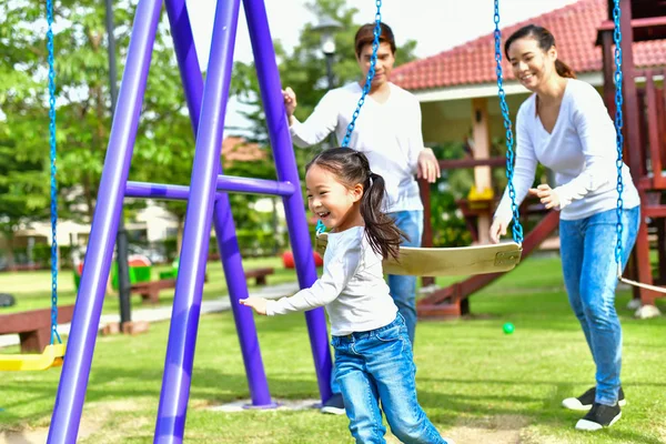 Im Park spielen Eltern mit dem Baby. — Stockfoto