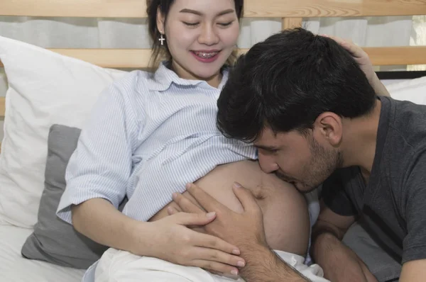 O homem e a mulher grávida estão fazendo atividades domésticas . — Fotografia de Stock