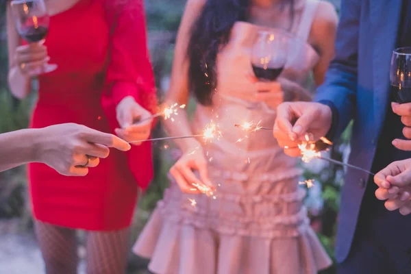 Mladí lidé držící pyrotechniku na večírku. — Stock fotografie