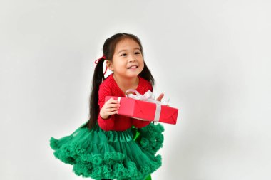 Küçük kız Noel kırmızı Santa elbise ile kutluyor..