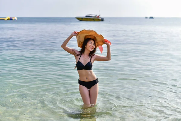 Hermosa mujer usando un traje de baño jugando en la playa . — Foto de Stock