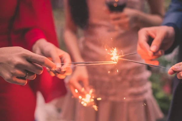 Young people holding fireworks at a party. — Stock Photo, Image