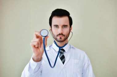 Ofiste poz doktor gülümseyen, o bir stetoskop giyiyor