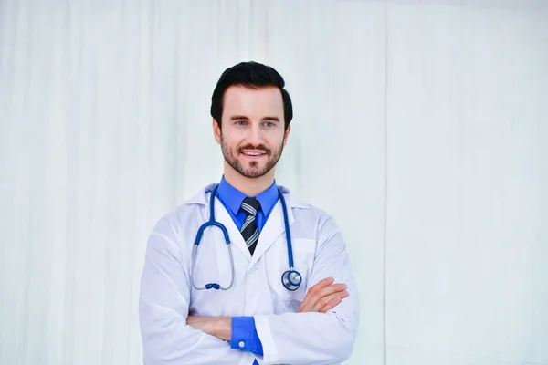Χαμογελαστός ο γιατρός που ποζάρουν στο γραφείο, φοράει ένα στηθοσκόπιο — Φωτογραφία Αρχείου
