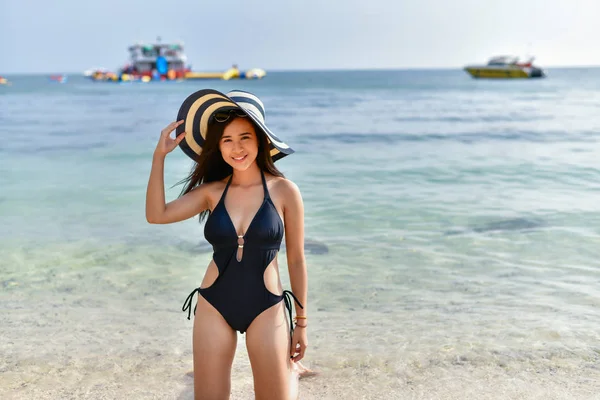 Mulher bonita vestindo um maiô jogando na praia . — Fotografia de Stock