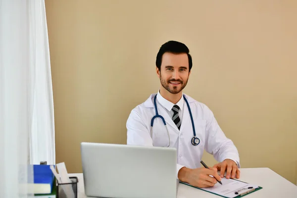 Médico sonriente posando en la oficina, lleva un estetoscopio — Foto de Stock