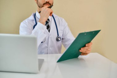 Ofiste poz doktor gülümseyen, o bir stetoskop giyiyor