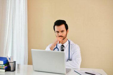 Ofiste poz doktor gülümseyen, o bir stetoskop giyiyor