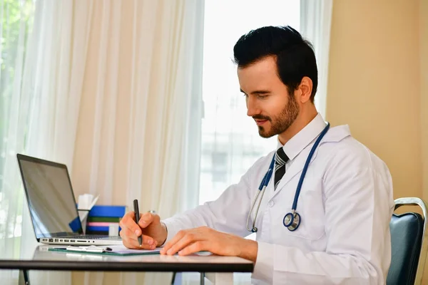 Médico sorridente posando no escritório, ele está usando um estetoscópio — Fotografia de Stock