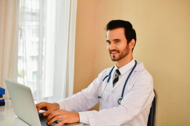 Ofiste poz doktor gülümseyen, o bir stetoskop giyiyor