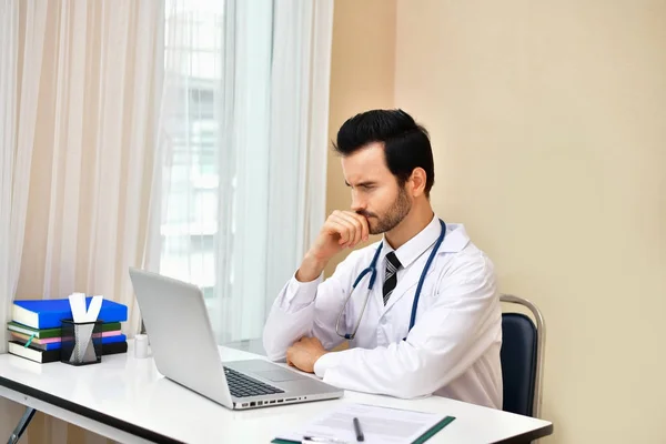 Dokter tersenyum berpose di kantor, ia mengenakan stetoskop — Stok Foto