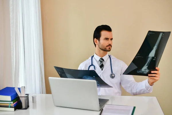 S úsměvem lékař pózuje v kanceláři, má na sobě stetoskop — Stock fotografie