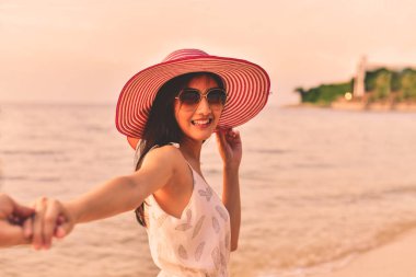 Güzel kız sahilde mutlulukla yürüyor.