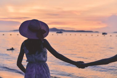 Güzel kız sahilde mutlulukla yürüyor.