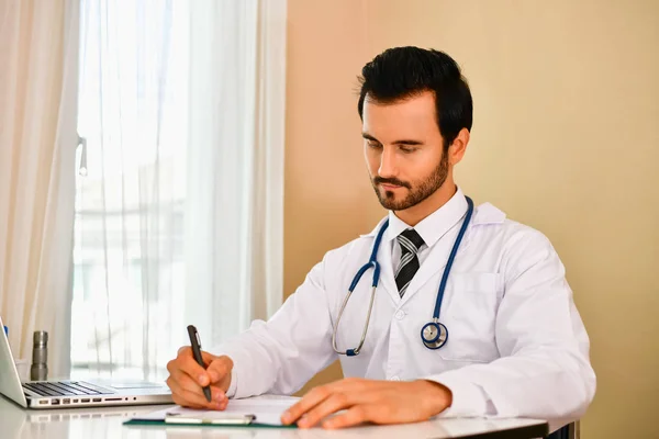 Médico sorridente posando no escritório, ele está usando um estetoscópio — Fotografia de Stock