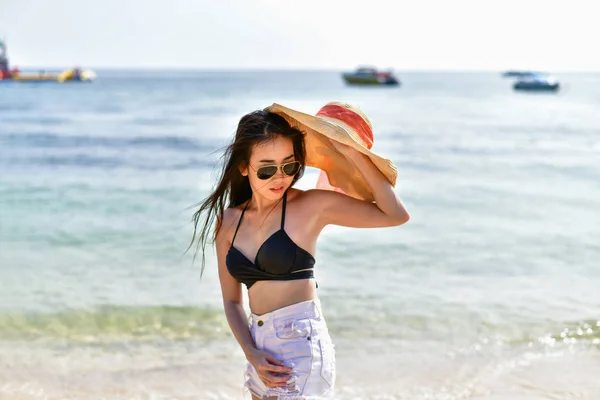 Mulher bonita vestindo um maiô jogando na praia . — Fotografia de Stock