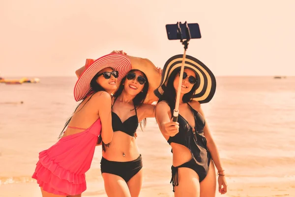 Piękna dziewczyna ubrana w strój kąpielowy gry mobilne na plaży. — Zdjęcie stockowe