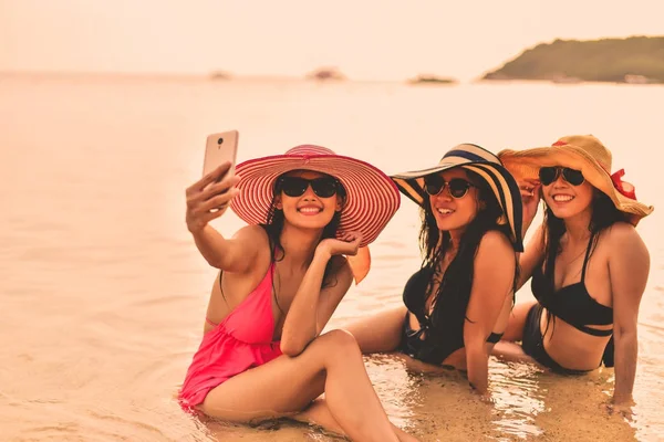 Piękna dziewczyna ubrana w strój kąpielowy gry mobilne na plaży. — Zdjęcie stockowe