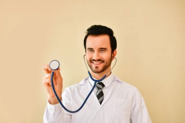 Ofiste poz doktor gülümseyen, o bir stetoskop giyiyor