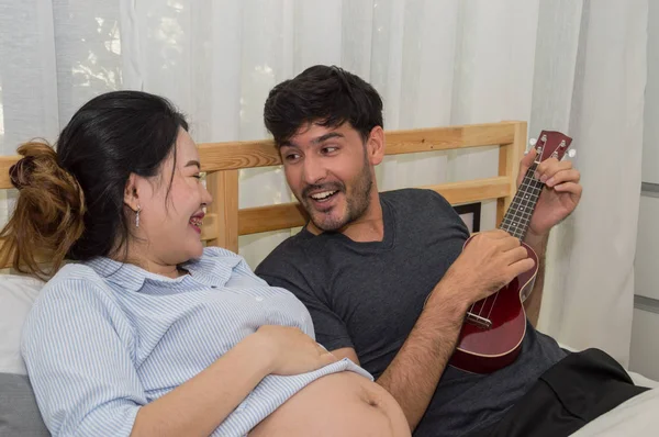 Homens tocando música para mulheres grávidas no quarto . — Fotografia de Stock