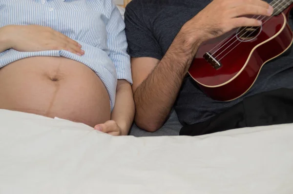 Yatak odasında hamile kadınlar için müzik erkekler. — Stok fotoğraf