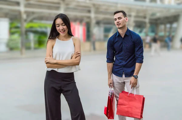 Feliz pareja joven con bolsas de compras caminando en el centro comercial — Foto de Stock