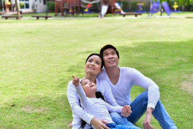 Mutlu erkek ve kadın dışarıda çocuklarla oynuyor.