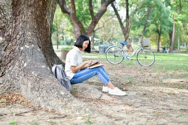 Концепции образования. Азиатки читают книги в парке. Бо — стоковое фото