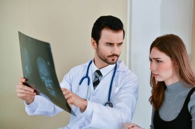Sağlık kavramları. Doktor ve hasta röntgen filmi ile ilgilenen. Doct