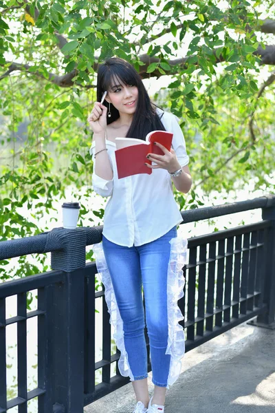 Conceptos educativos. Mujeres asiáticas leyendo libros en el parque. Beaut. — Foto de Stock
