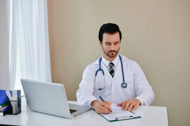 Ofiste poz doktor gülümseyen, o bir stetoskop giyiyor